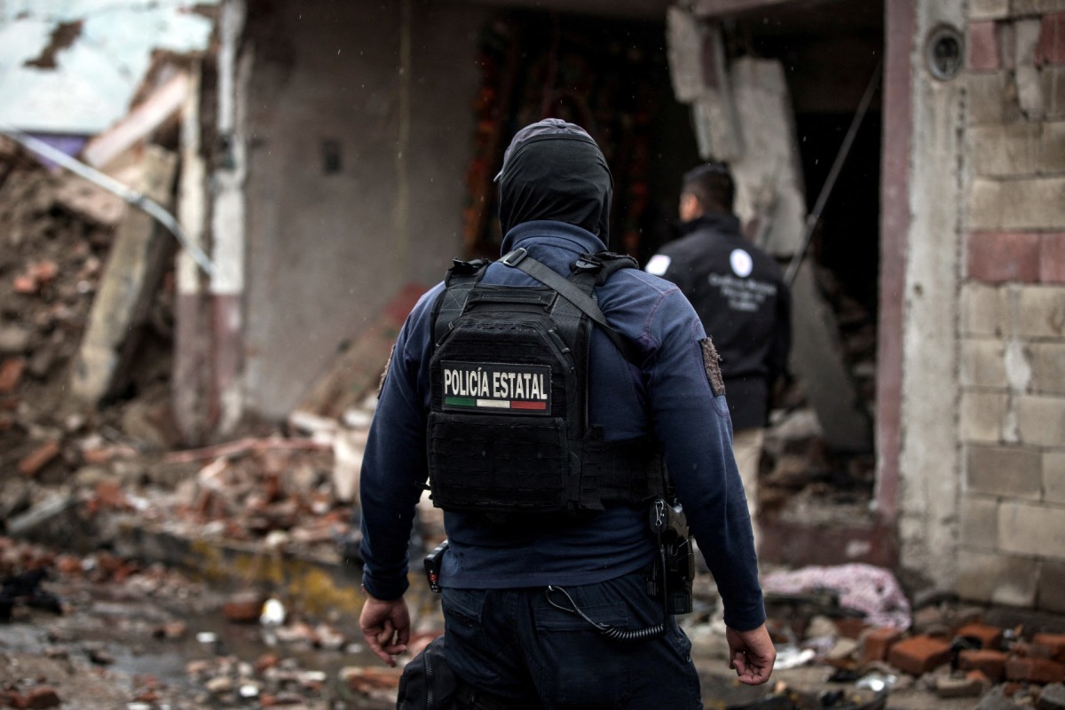 A State Police officer walks amid remains caused by a car bomb explosion outside the municipal police station in Ojocaliente, Zacatecas, Mexico, on August 31, 2026. Photo by JESS MIRELES / AFP