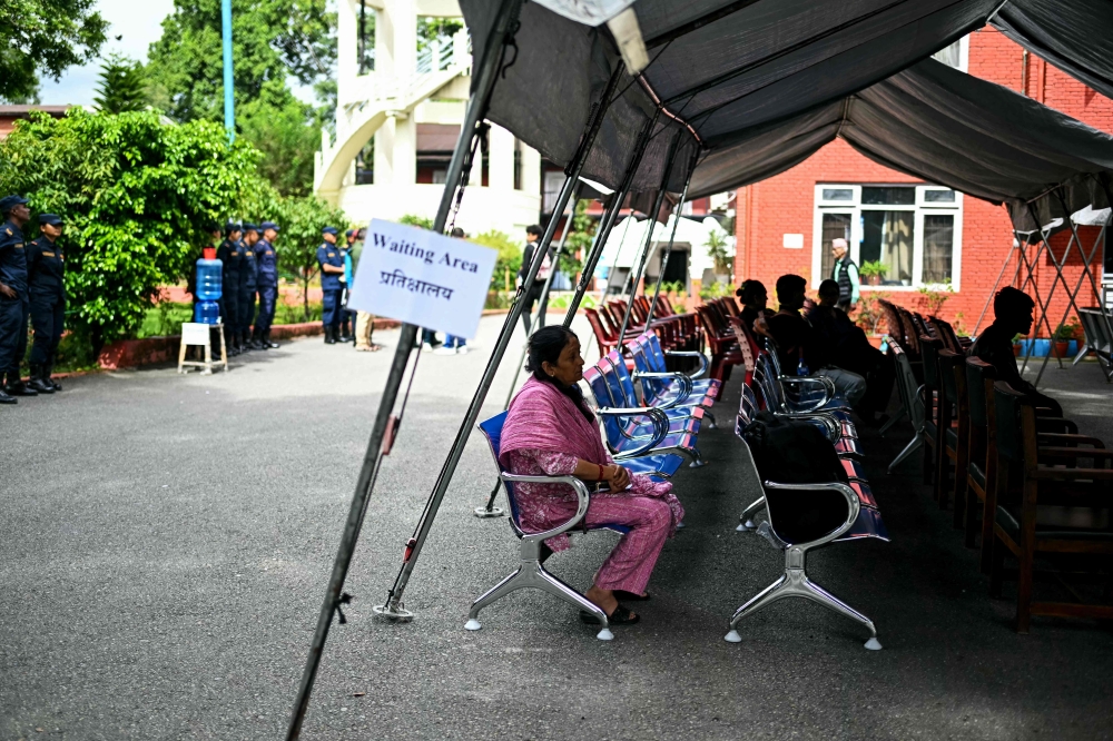 Family members wait to register their information with police personnel to give blood samples for DNA testing to help identify their missing relatives after flash floods, at the Nepal Police Hospital in Kathmandu on September 3, 2026.  (Photo by Manan VATSYAYANA / AFP)
 