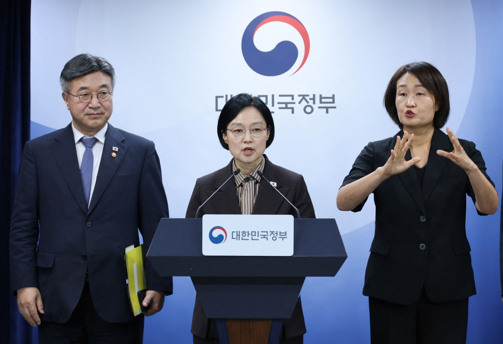 Republic of Korea Prime Minister Han Seong-sook (C) speaks as Interior and Safety Minister Yun Ho-jung (L) looks on during a press conference announcing the relocation plan of government agencies at the government complex in Seoul on September 3, 2026. (Photo by YONHAP / AFP) 