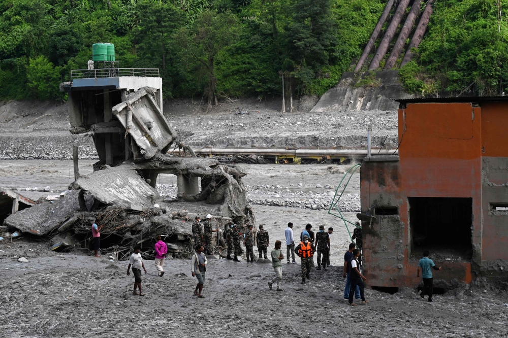 Security and relief personnel stand along the Trishuli riverbank in the aftermath of flash floods at Trishuli Bazar in Nepal's Nuwakot district on September 5, 2026. (Photo by Prakash MATHEMA / AFP)