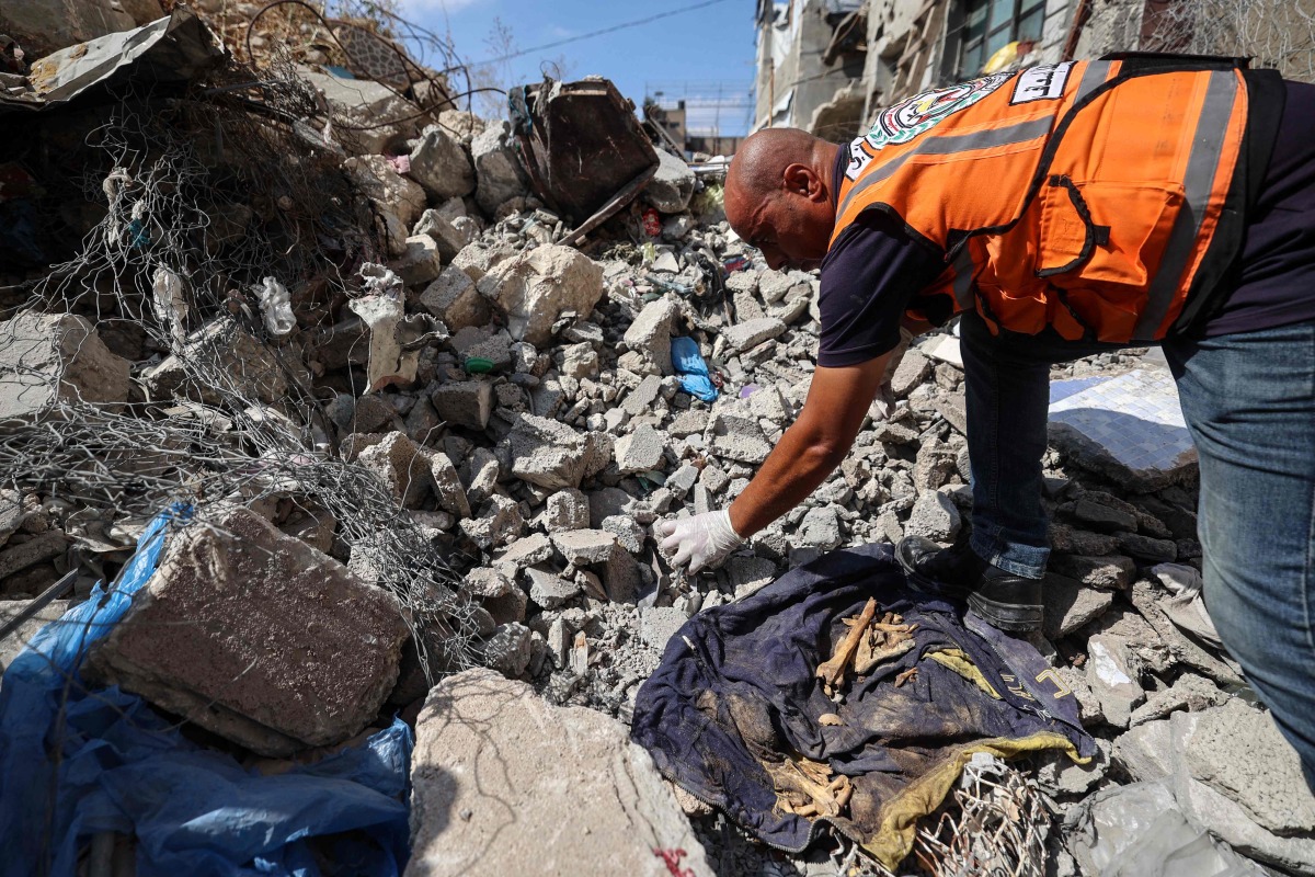 A Civil Defence member collects human remains in the rubble of Al-Muhandisin Tower, that was destroyed in Israeli strikes in the Nuseirat camp for refugees in the central Gaza Strip on September 5, 2026. (Photo by Eyad BABA / AFP)