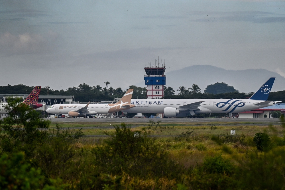 Airplanes sit on the tarmac at Iskandar Muda airport in Blang Bintang on September 6, 2026. Indonesia halted operations at its main international airport outside Jakarta on September 6, after ash spewed from the Anak Krakatoa volcano more than 150 kilometres away, impacting thousands of passengers. (Photo by CHAIDEER MAHYUDDIN / AFP)