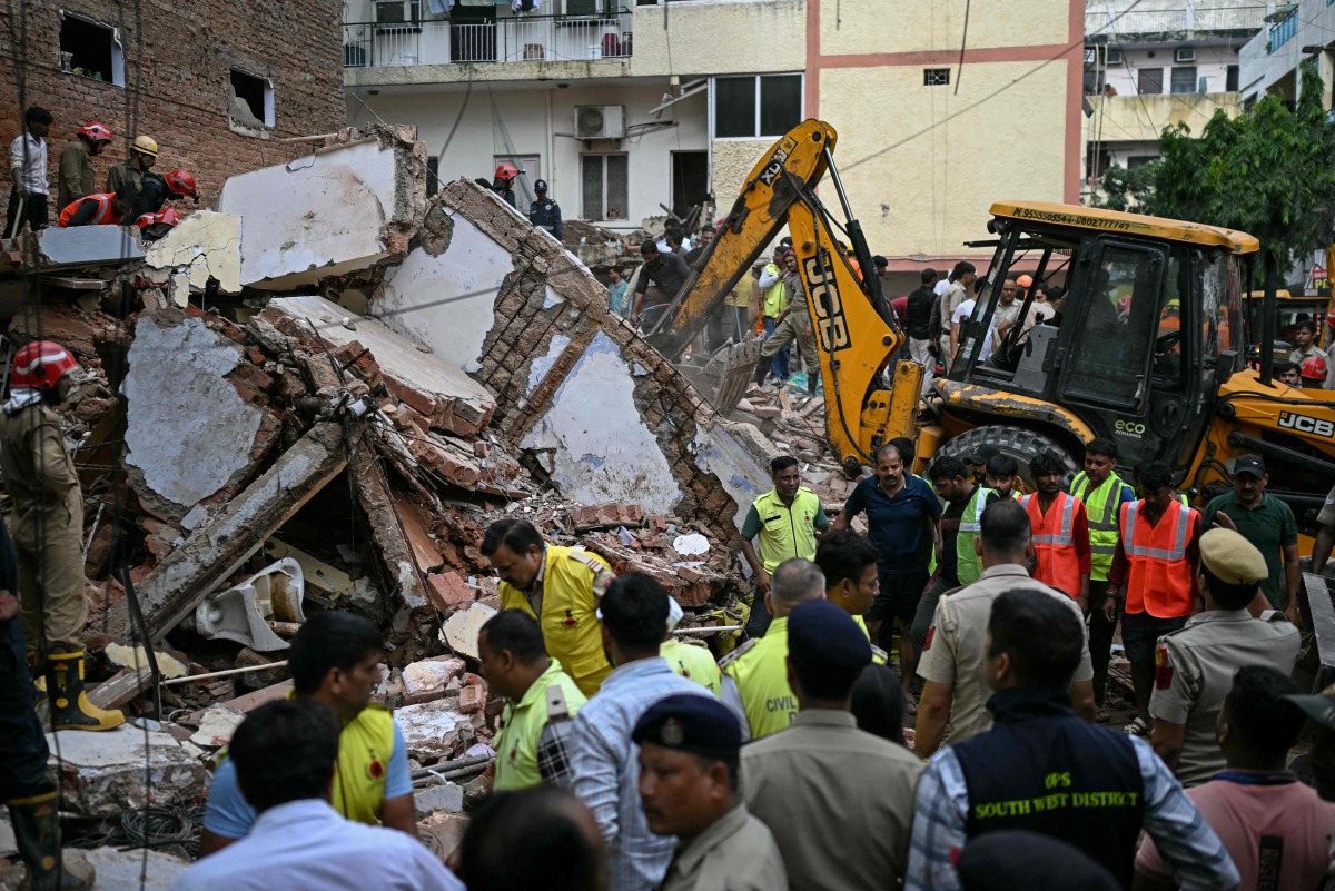 Bulldozers clear debris as rescue personnel conduct a search operation at the site following a building collapse in the Satya Niketan area in New Delhi on September 6, 2026. (Photo by Sajjad HUSSAIN / AFP)