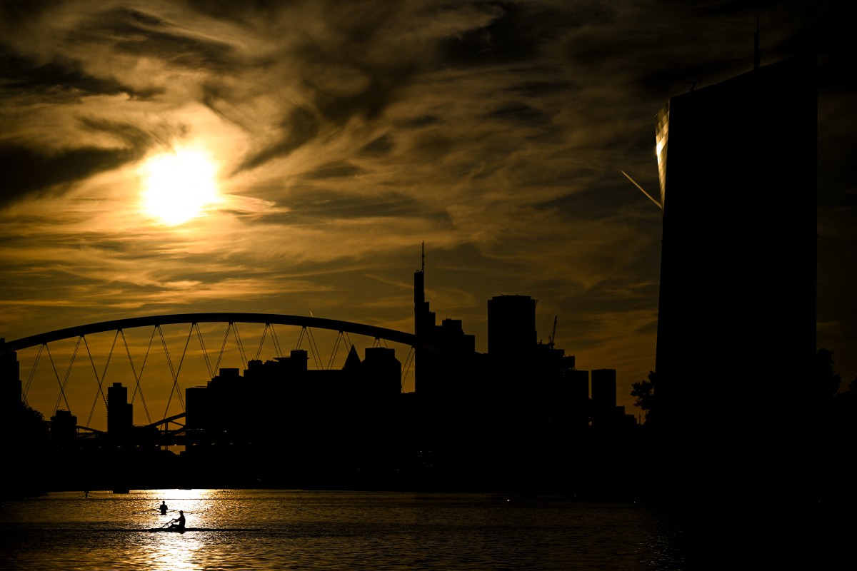 People row on the Main river during the sunset in front of the European Central Bank's (ECB) headquarters and banking district skyline in Frankfurt am Main, western Germany, on September 1, 2026. (Photo by Kirill KUDRYAVTSEV / AFP)
