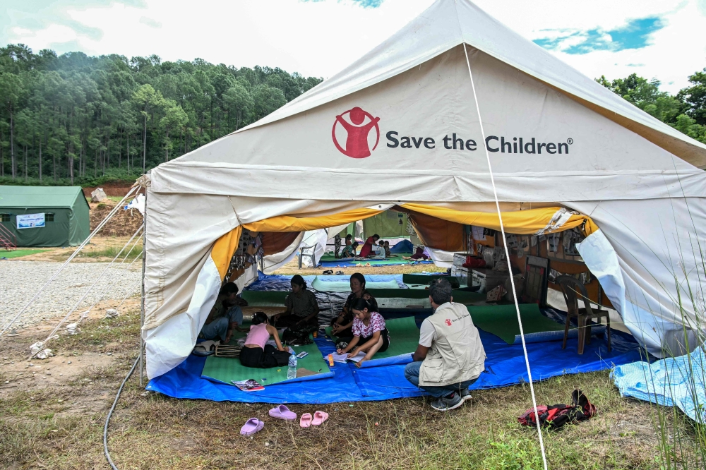 Children, separated from their parents from the flash floods, study at a temporary learning centre run by Save the Children charity in Nepal's Nuwakot district on September 11, 2026. (Photo by Prakash Mathema / AFP) 