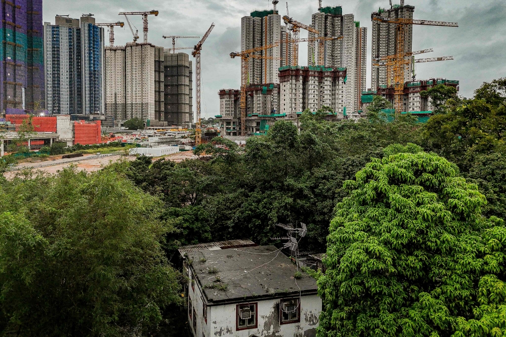 An aerial view shows the home of Kwu Tung resident Niki So in the foreground, as surrounding land is transformed into construction sites under Hong Kong's Northern Metropolis development plan, in Hong Kong, on June 17, 2026. (Photo by Leung Man Hei / AFP)