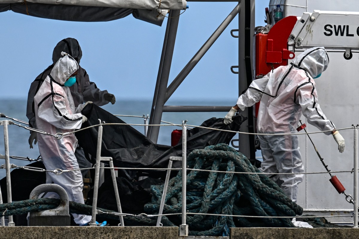 Philippine Coast Guard personnel in protective suits carry a body bag of a victim from the ferry fire to a tent for identification at the port of Borac in Coron, Palawan province on September 13, 2026. Photo by JAM STA ROSA / AFP