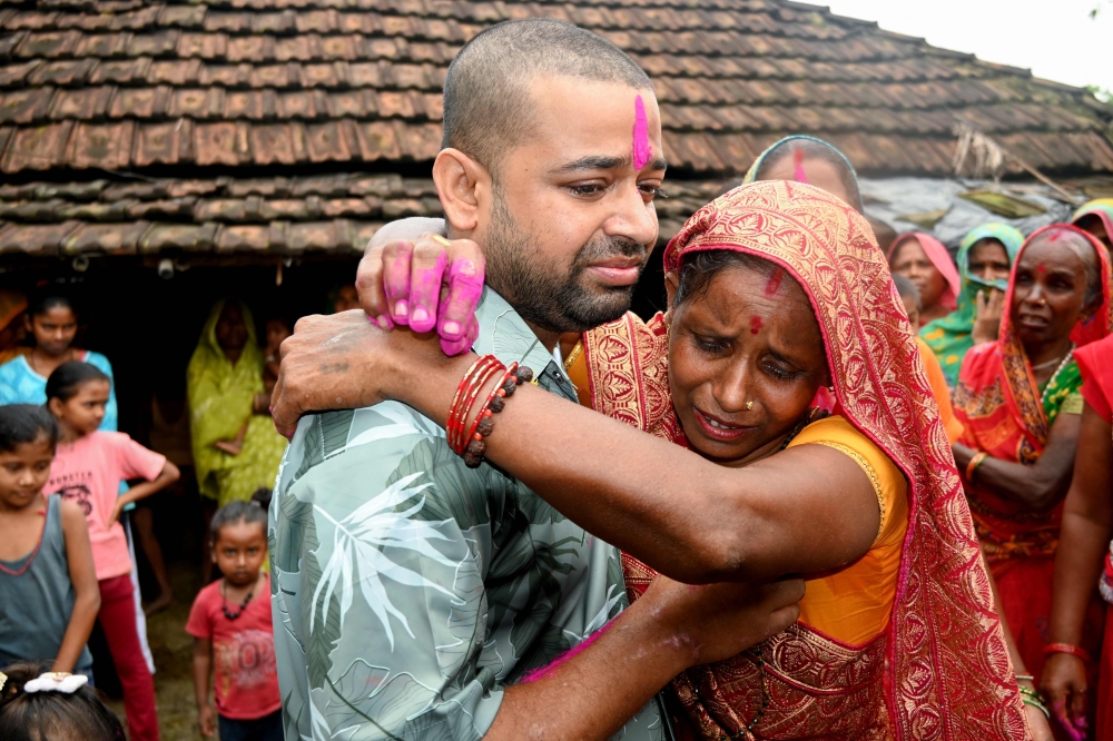 Nepali hydropower worker Sanjay Sah (L) breaks down after meeting his mother at his residence in Nepal's Saptari district on September 13, 2026 after being rescued. (Photo by Deepesh Deo Joshi / AFP)