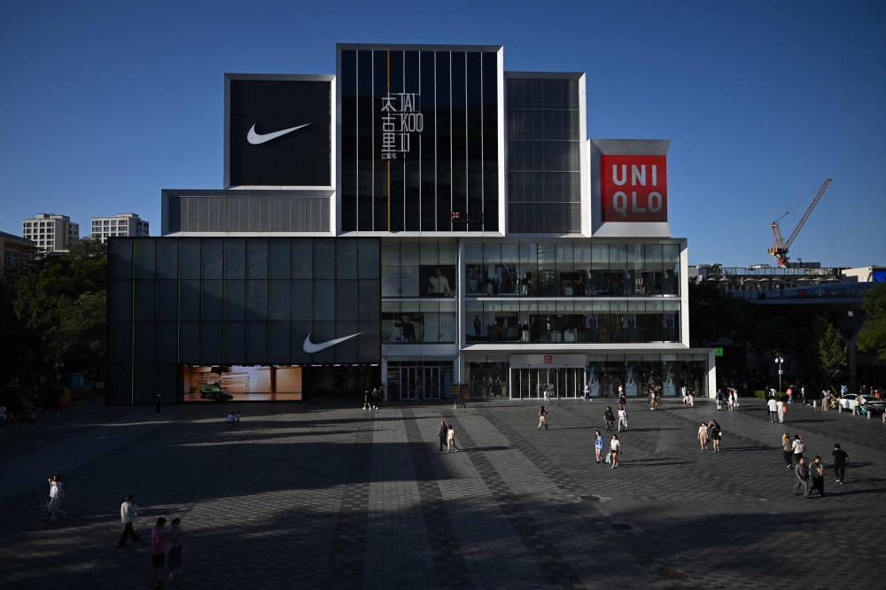 People visit a shopping mall in Beijing on September 13, 2026. (Photo by Pedro Pardo / AFP)