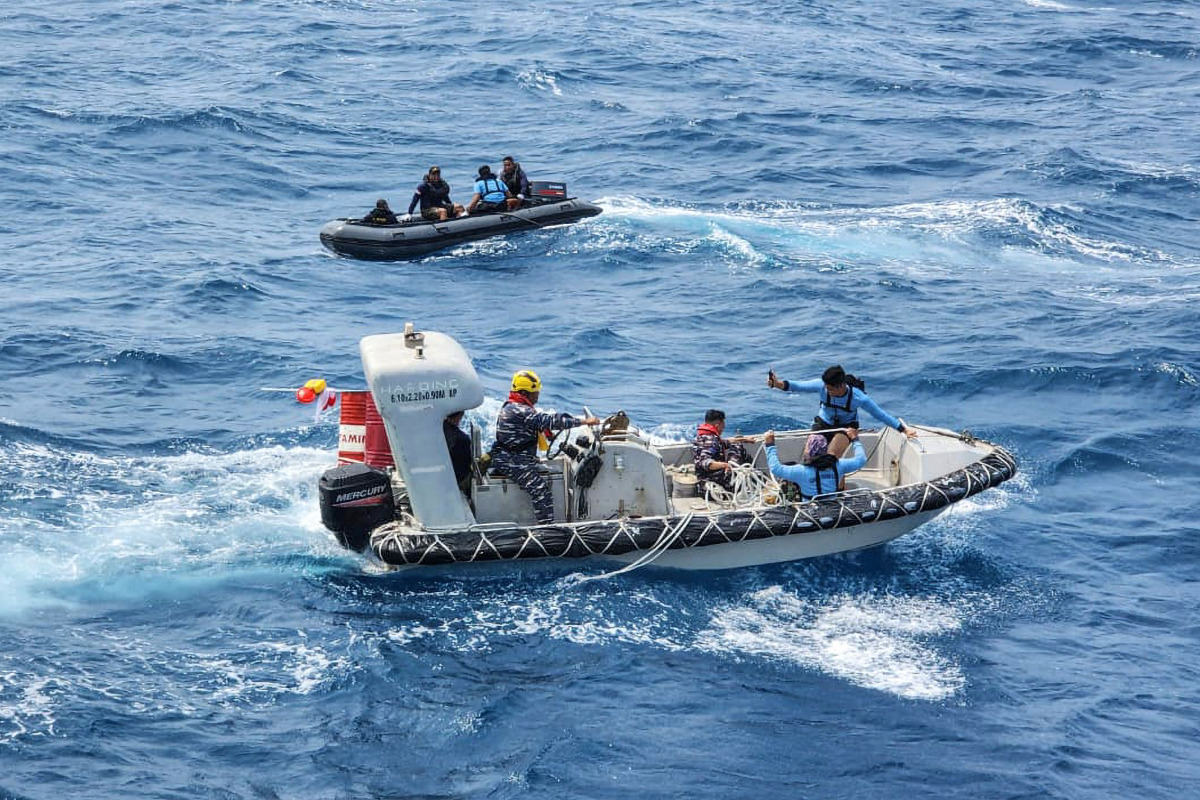 This handout picture taken on September 17, 2026, and released on September 18, 2026 by the Indonesian Navy shows navy personnel maneuvering their boats directly above the passenger ship Virgo Transport 8 which capsized in the Java Sea waters. (Photo by Handout / INDONESIAN NAVY / AFP)