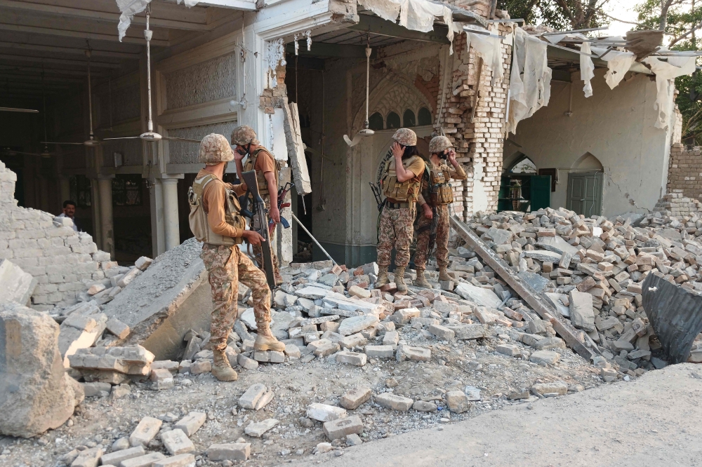 Army personnel stand amid the rubble following an explosion inside the police headquarters at Kohat in Pakistan's Khyber Pakhtunkhwa province on September 18, 2026. (Photo by Basit Shah / AFP)