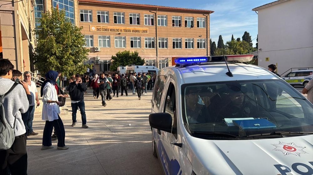 This handout photograph by Turkish news agency DHA (Demiroren News Agency) shows ambulances and police officers in front of the high school in Turgutlu. (Photo by Handout / DHA / AFP)
