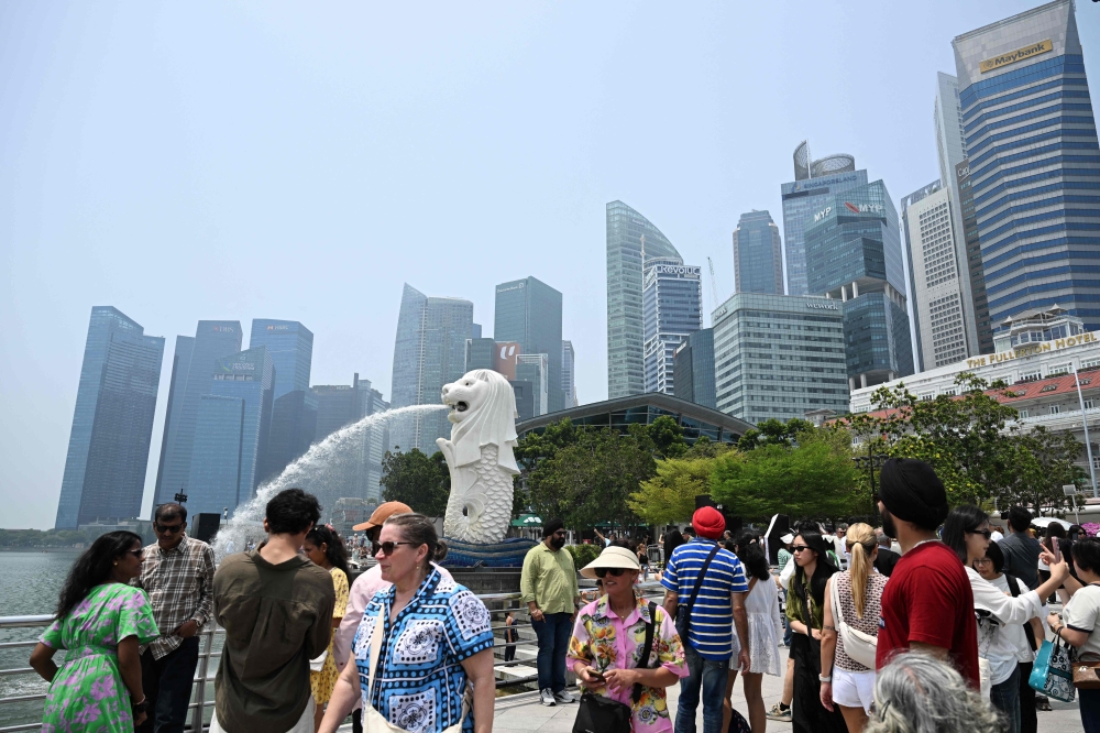 People gather at Marina bay waterfront in Merlion park in Singapore on September 29, 2026. (Photo by Roslan Rahman / AFP)