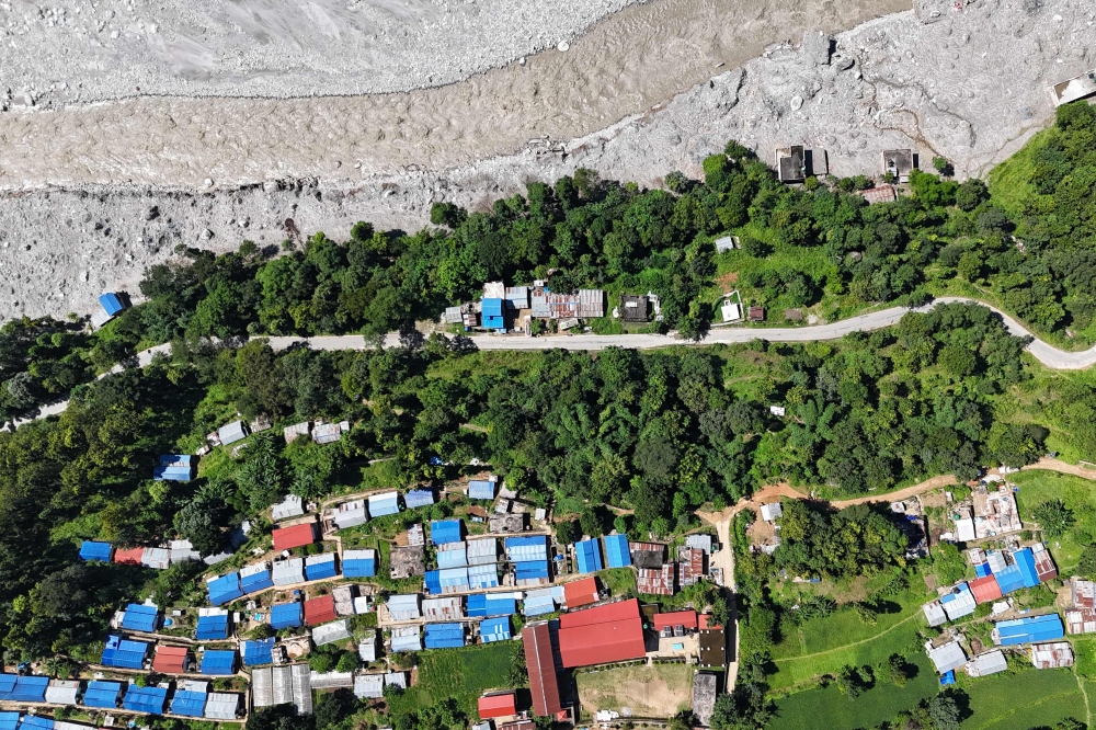 An aerial view shows damaged houses covered in sludge in the aftermath of the August 26 flash flood, at Betrawati Bazaar in Nepal's Rasuwa district on September 28, 2026.  (Photo by PRAKASH MATHEMA / AFP)