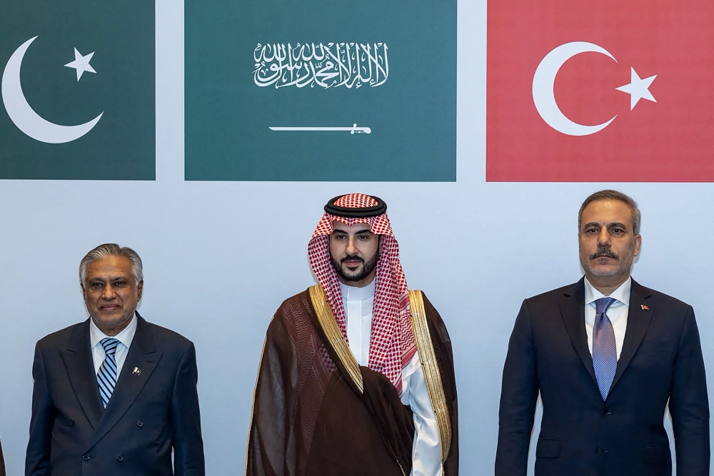 This handout photograph taken and released by the Turkish Foreign Ministry on October 5, 2026 shows (L-R) Pakistan's Deputy Prime Minister and Minister for Foreign Affairs Ishaq Dar, Saudi Defence Minister Prince Khalid bin Salman Al Saud and Turkish Foreign Minister Hakan Fidan posing during a meeting of the Strategic Political and Defense Committee, established under the Mecca Joint Defense Agreement, in Riyadh. (Photo by Handout / Turkish Foreign Ministry / AFP)