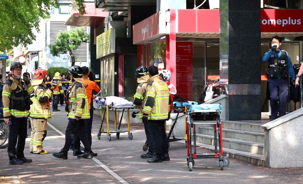 Police officers and firefighters arrive at the scene after a stabbing incident at a supermarket in Incheon on October 13, 2026. (Photo by YONHAP / AFP) 
