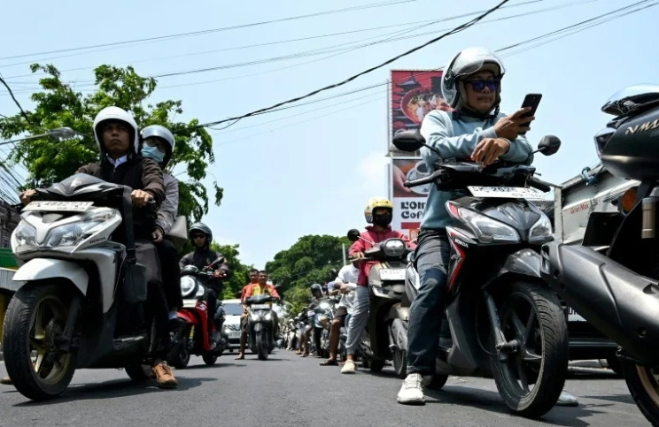Motorcyclists queue to refuel at a gas station in Denpasar amid a fuel supply shortage on Indonesia's resort island of Bali on Oct 14, 2026. (Photo: AFP/Sonny Tumbelaka)