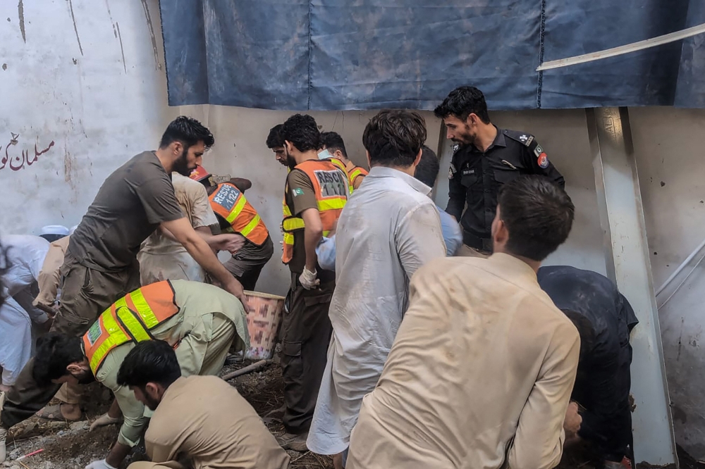 This photograph taken and released by the Khyber Pakhtunkhwa province's Emergency Service (Rescue 1122) on October 15, 2026 shows rescue workers during a search operation after a roof collapsed at a school in Peshawar. (Photo by Handout / Khyber Pakhtunkhwa province's Emergency Service (Rescue 1122) / AFP)