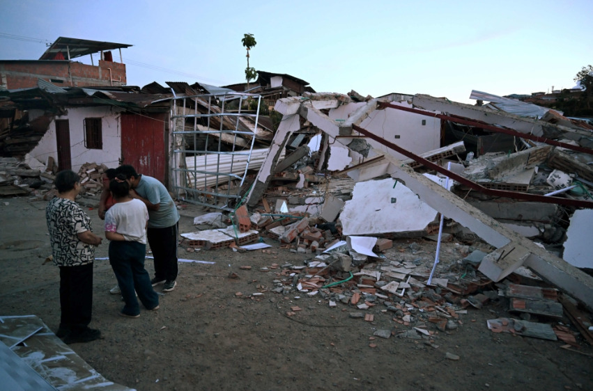 People gather in front of a house damaged by an earthquake in Colombia. AFP file photo.