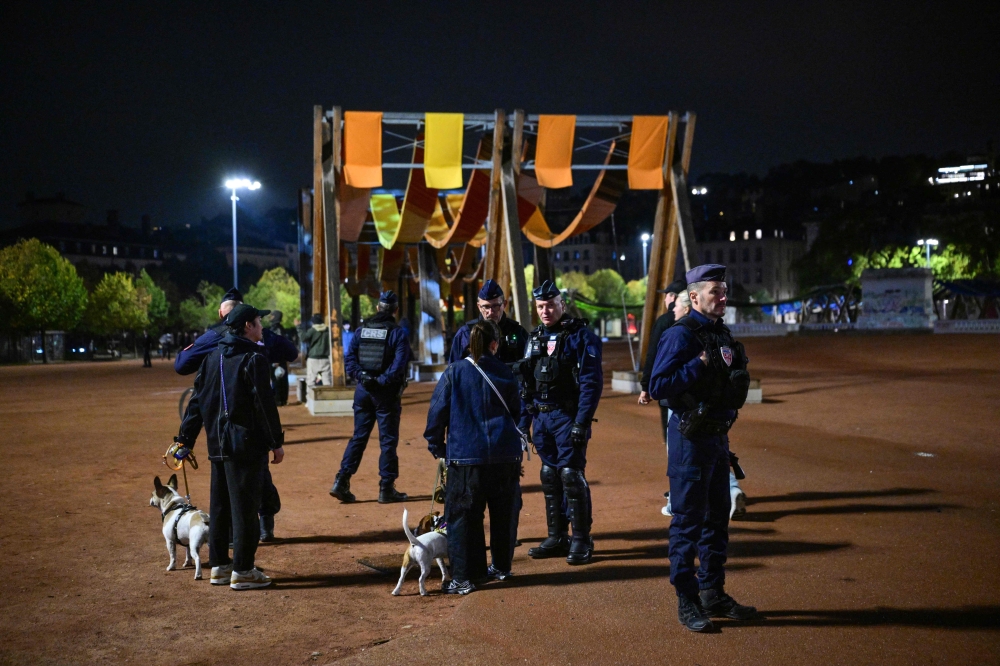 French police officers check people during a partial curfew in Lyon on October 19, 2026, following weekend demonstrations. (Photo by Olivier Chassignole / AFP)