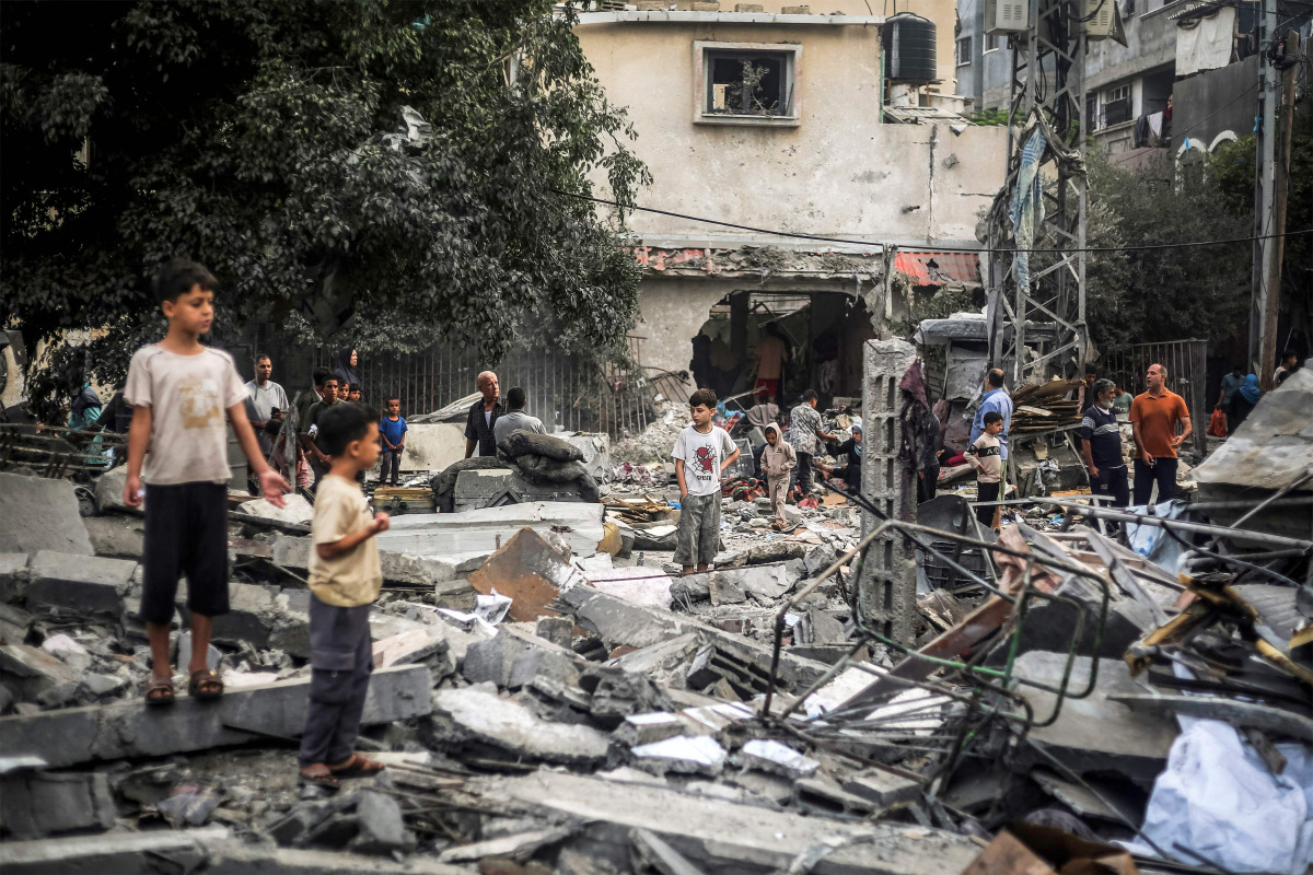 Children stand by the rubble of a destroyed building following an Israeli airstrike in Nuseirat in the central Gaza Strip on October 23, 2026. (Photo by EYAD BABA / AFP)