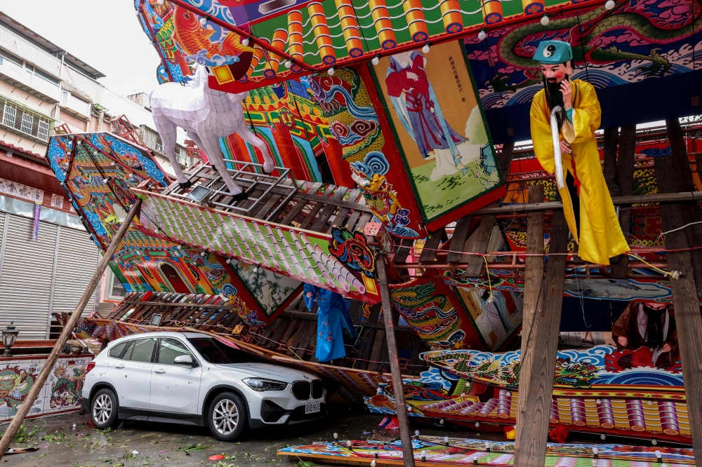 A temporary structure built for a traditional Taoist religious ceremony lies collapsed due to strong winds from Typhoon Champi in Keelung on October 24, 2026. (Photo by I-Hwa Cheng / AFP)
