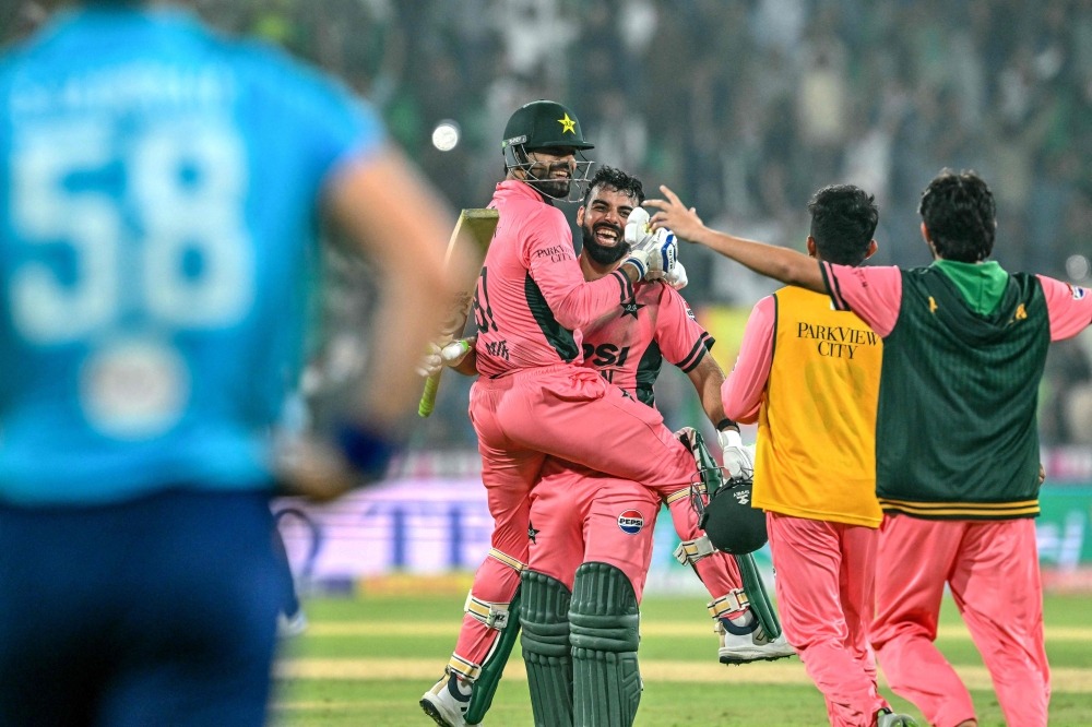 Pakistan's Shadab Khan (2L) and Haris Rauf (L) celebrate after their team's victory in the one-day international (ODI) tri-series cricket match against England at the Gaddafi Stadium in Lahore on October 25, 2026. (Photo by ARIF ALI / AFP)