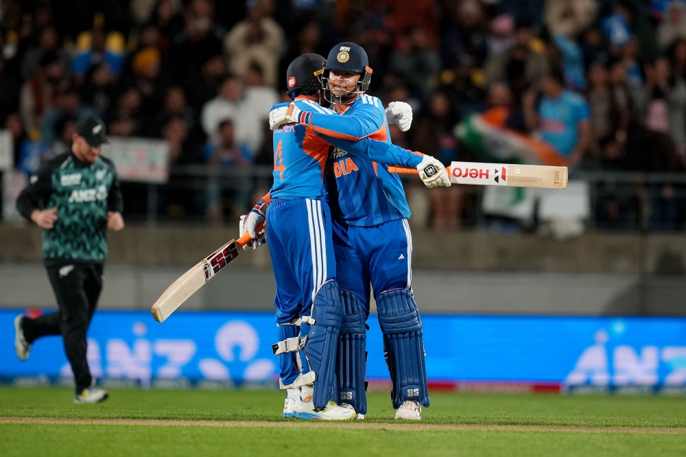 India's Abhishek Sharma (L) hugs teammate Vaibhav Sooryavanshi during the 3rd T20 cricket match between New Zealand and India. (Photo by Marty Melville / AFP)