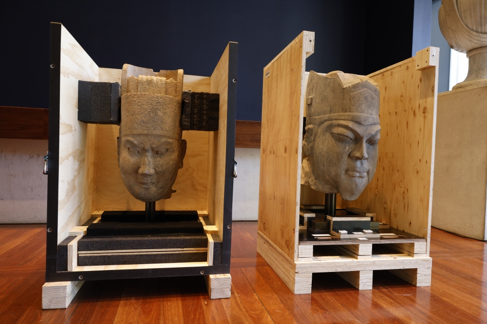 This photo shows two Chinese cultural relics, the head of a military official statue (L) and the head of a civil official statue, returned from Australia, in Canberra, Australia. (Photo by Chu Chen/Xinhua) 
